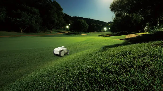 FJD FRX robotic mower cutting golf course turf at night