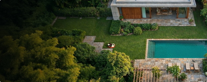 Kress EyePilot robotic mower on a landscaped backyard lawn beside a swimming pool, aerial view