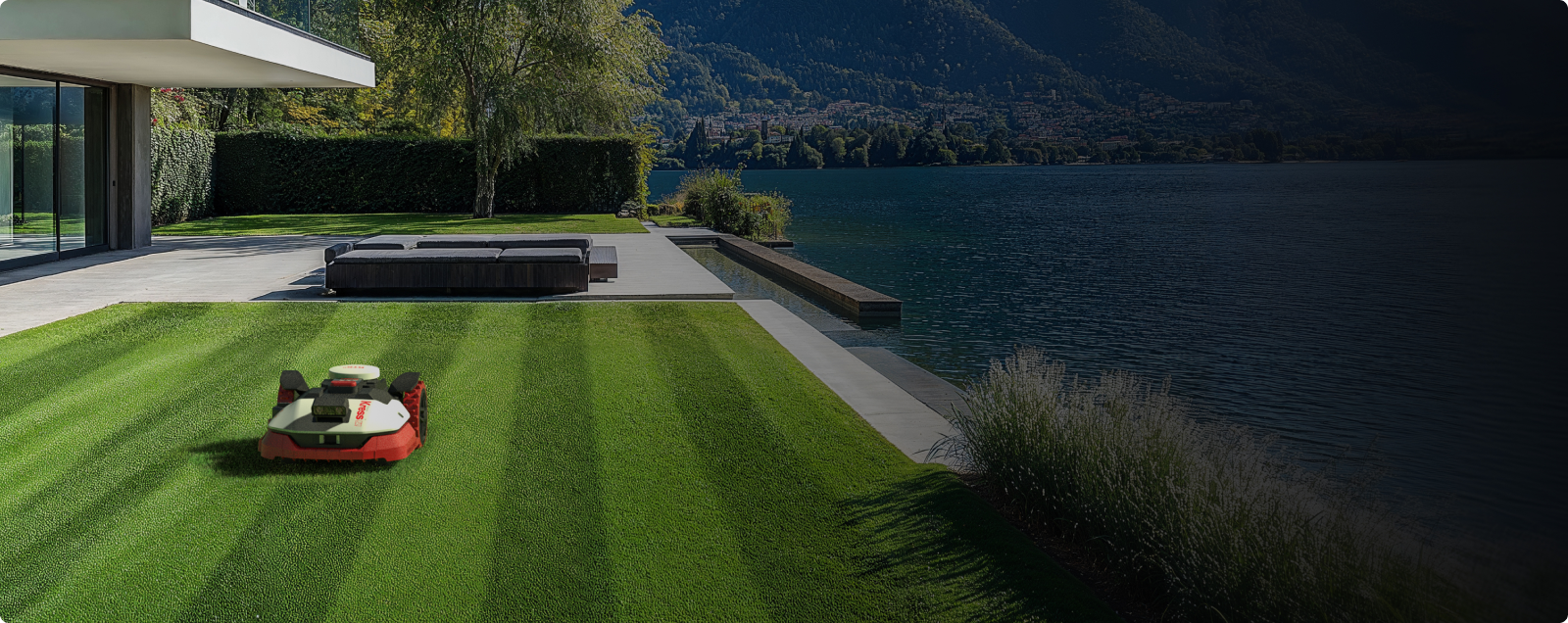 Kress EyePilot robotic mower creating lawn stripes on a lakeside lawn beside a modern home