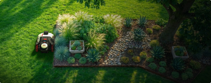 Kress EyePilot robotic mower mowing beside a landscaped garden bed of ornamental grasses and succulents