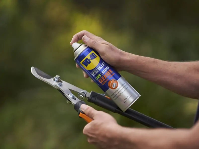 WD-40 Specialist Lawn & Garden Foaming Cleaner being sprayed onto garden tool to dissolve sap and resin